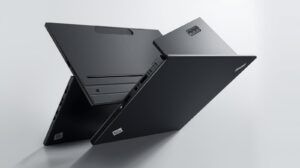 A person using a stylus pen on the tablet screen of a Lenovo ThinkPad X12 Detachable, with the keyboard folio lying nearby.